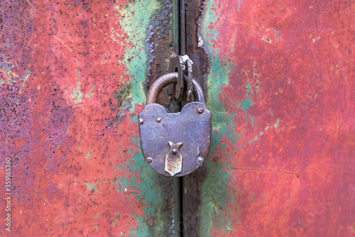 Closed on an old padlock metal door leaf