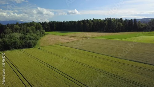 Vue aérienne par drone au-dessus de la campagne ensoleillée et de ses champs dans le canton de Vaud en Suisse romande le vol est calme avec un vol vers l'avant et une courbe à droite