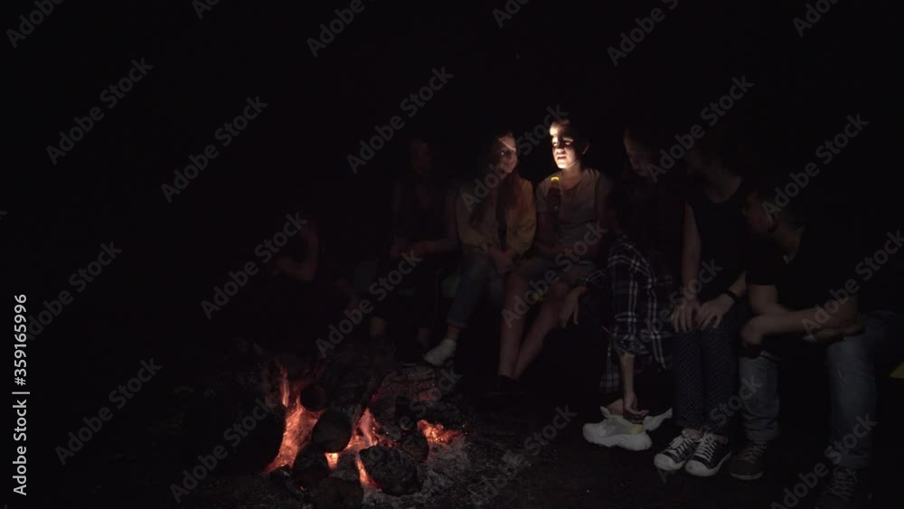 Teenager telling scary story using flashlight on face. Teenager telling scary story using flashlight on face.