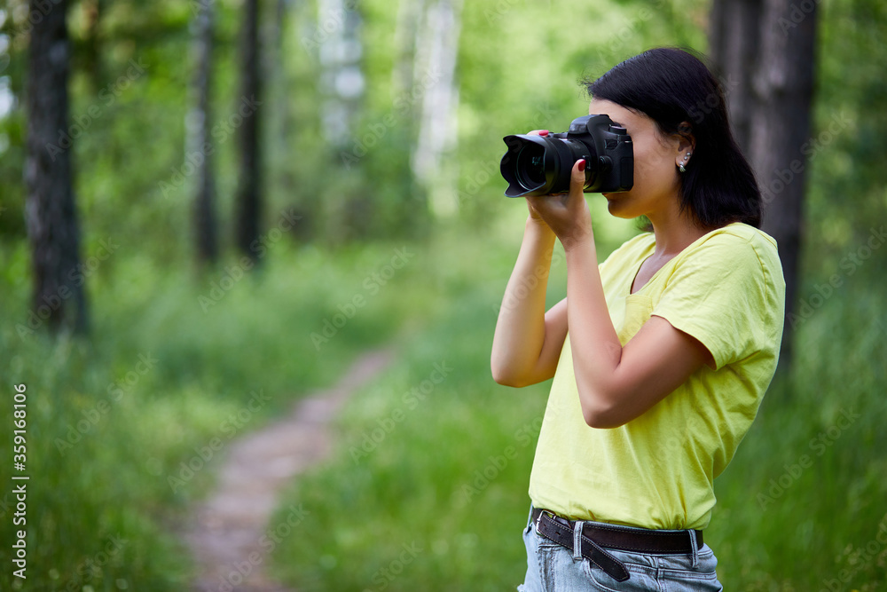 Portrait of a woman photographer covering her face with the camera