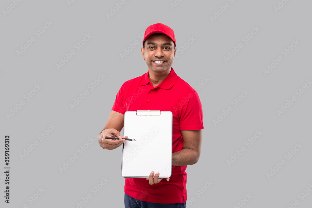 Delivery Man Pointing at clipboard Watching in Camera. Indian Delivery Boy Clipboard