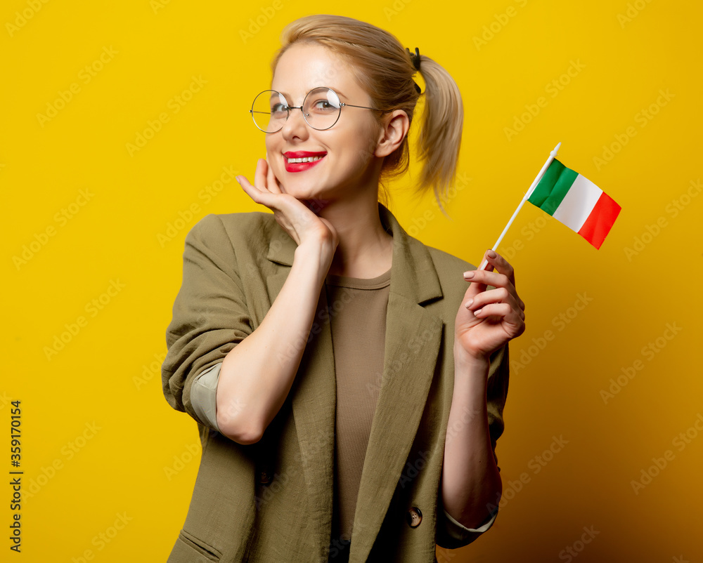 Style blonde woman in jacket with Italian flag on yellow background Style blonde woman in jacket with Italian flag on yellow background