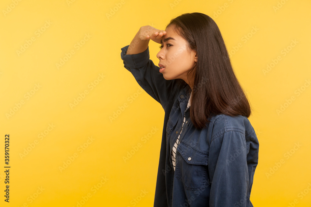 Φωτογραφία Side view of curious girl in denim shirt looking carefully far away with hand over eyes, choosing distance, exploring horizon with attentive view