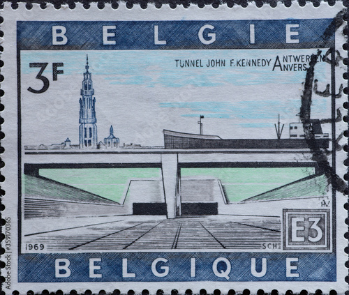 BELGIUM - CIRCA 1969: A postage stamp from Belgium showing a ship in the canal with a tunnel. Text: Schelde tunnel John F Kennedy photo