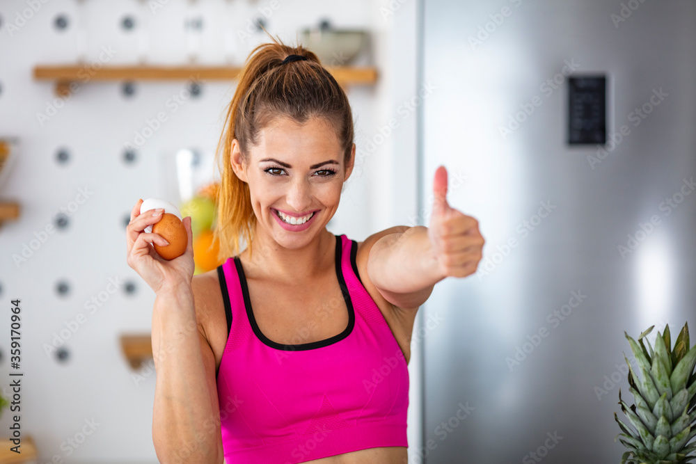 Young beautiful woman holding fresh egg at home with surprise face. Woman taking eggs. Beautiful young woman showing egg with happy face. Healthy homemade oatmeal Young beautiful woman holding fresh egg at home with surprise face. Woman taking eggs. Beautiful young woman showing egg with happy face. Healthy homemade oatmeal