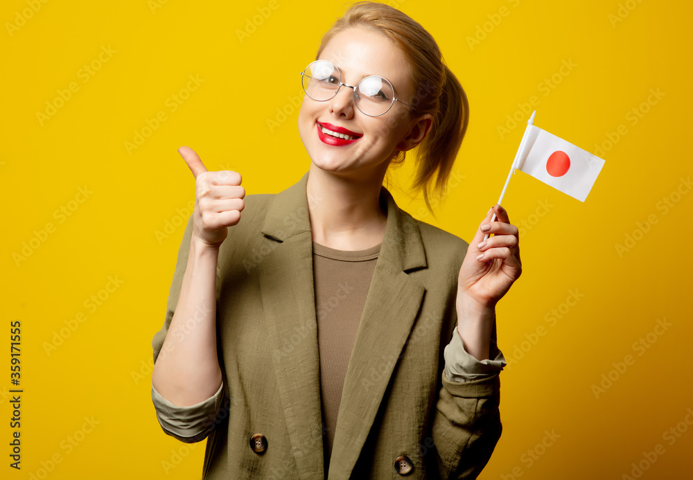 Style blonde woman in jacket with Japanese flag on yellow background Style blonde woman in jacket with Japanese flag on yellow background