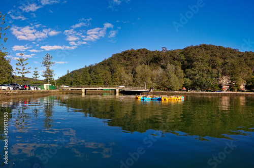 Beautiful morning view of Cowan creek with reflections of blue sky, boats, mountains and trees, Bobbin Head, Ku-ring-gai Chase National Park, New South Wales, Australia