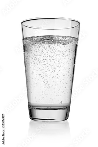 Glass of water with bubbles of gas isolated on white.