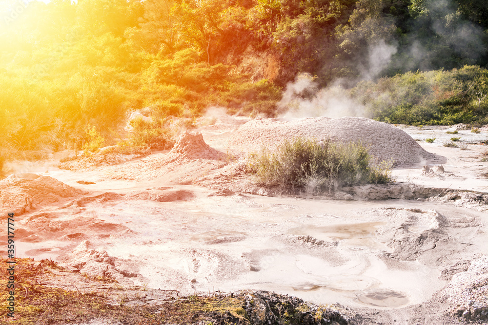 Sunlight over bubbling hot mud pool. Close up