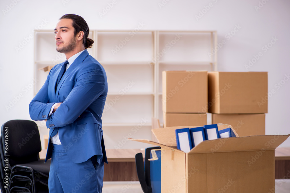 Young male employee in relocation concept Young male employee in relocation concept
