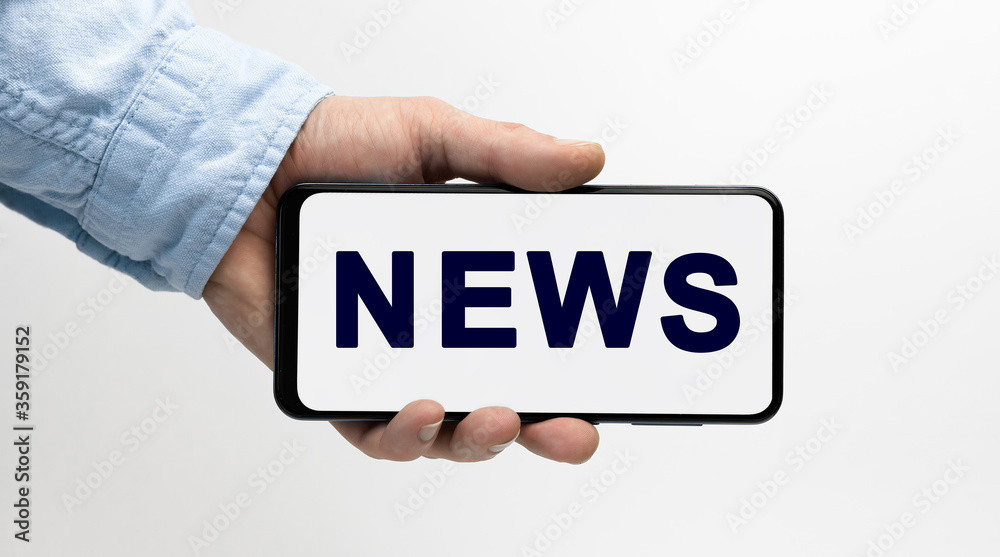 Man's hand holding smartphone with text NEWS on white background Man's hand holding smartphone with text NEWS on white background