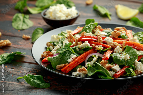 Roasted carrot salad with feta cheese, walnut and spinach. healthy food