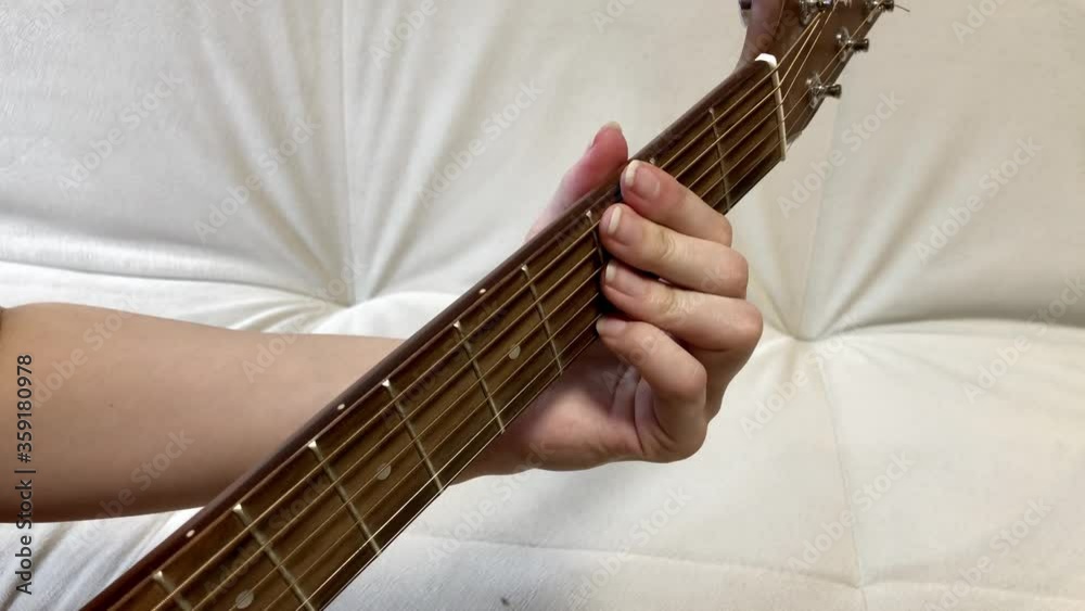 Fingering over the strings of a guitar. Enumerates the frets on the guitar fretboard