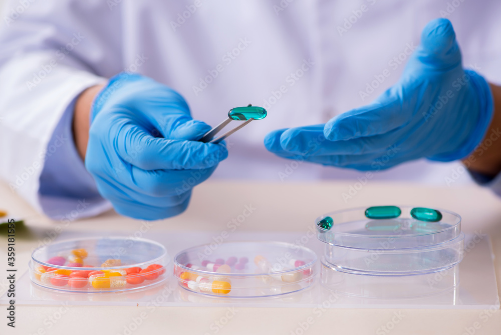 Young male lab assistant in drug synthesis concept Young male lab assistant in drug synthesis concept