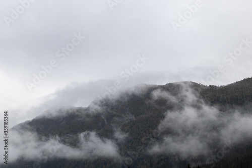 Clouds on forest in Norway mountains. Autumn travel wild nature. Foggy scandinavia cloudy landscape