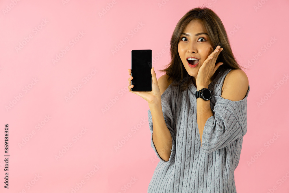 An Asian woman is surprised and holds a smartphone. An Asian woman is surprised and holds a smartphone.