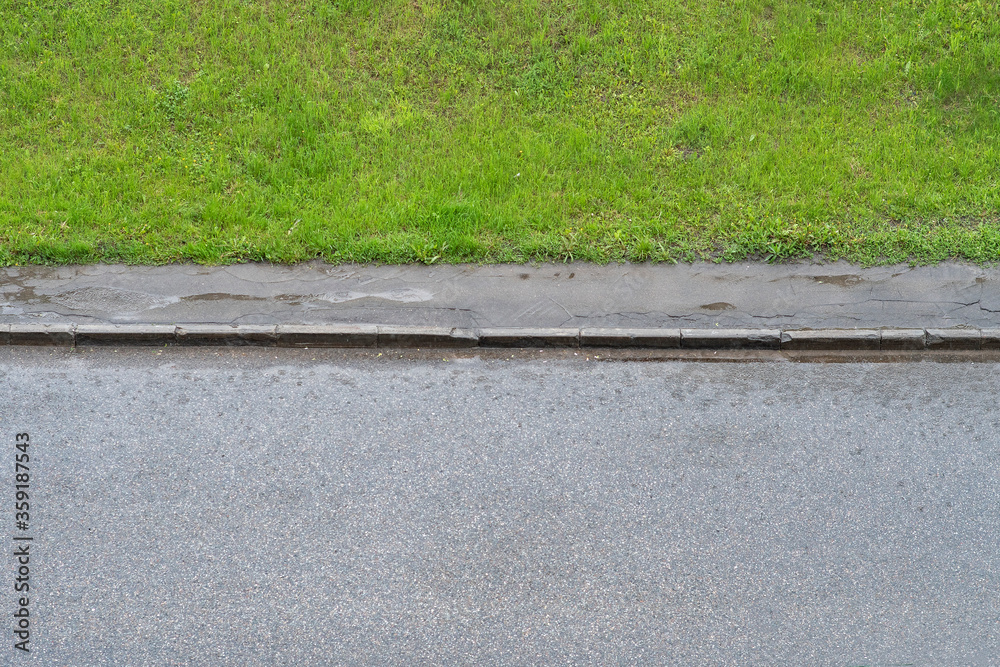 Fototapeta premium Wet road with sidewalk and lawn