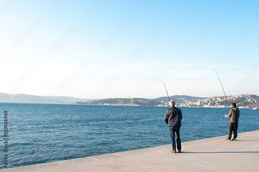 People fish from the Bosphorus. Fisherman fishing over bosphorus. Men fishing in Istanbul Strait.