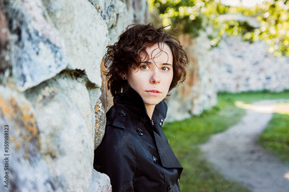 a girl lean on the stone wall of an ancient fortress a girl lean on the stone wall of an ancient fortress