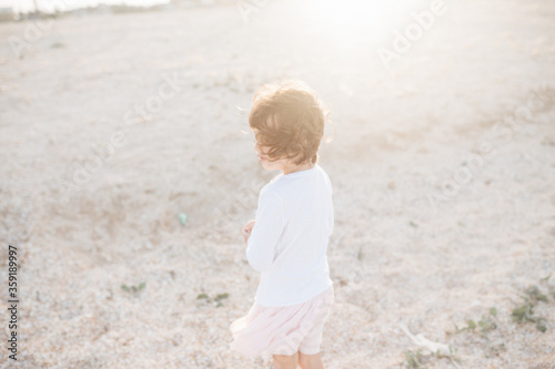 Little cute girl searching seashells on the sea beach © sweetlaniko