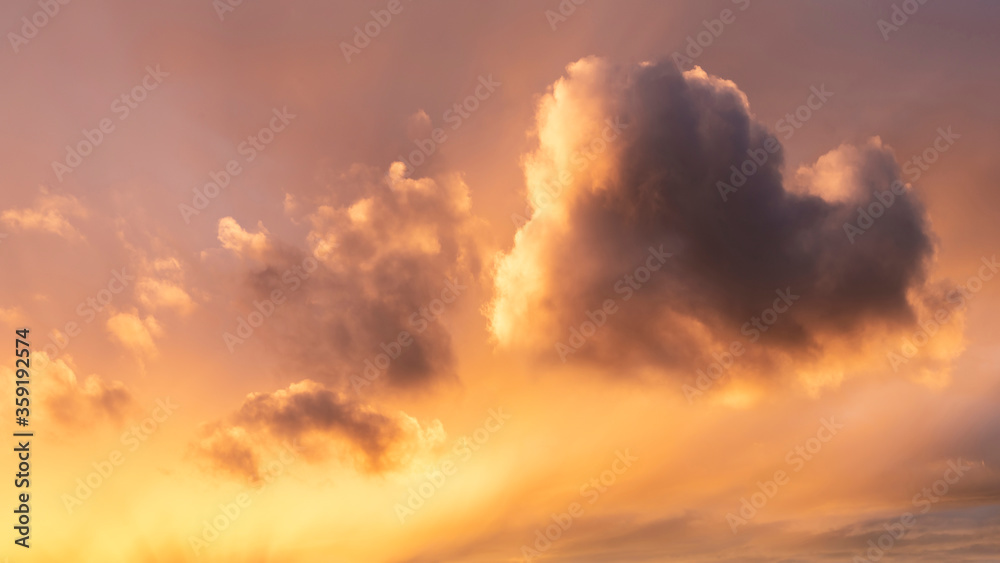 Fototapeta premium Stunning Summer sunset sky with heart shaped cloud and colorful vibrant clouds and sun beams across whole sky