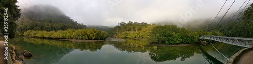 Beautiful morning panoramic view of Cockle creek with reflections of foggy sky, mountains and trees, Bobbin Head, Ku-ring-gai Chase National Park, New South Wales, Australia 