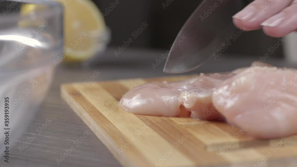 chicken breast cutting close-up. hand with a knife cuts meat into small slices on a wooden cutting board
chicken breast cutting close-up. hand with a knife cuts meat into small slices on a wooden cutting board