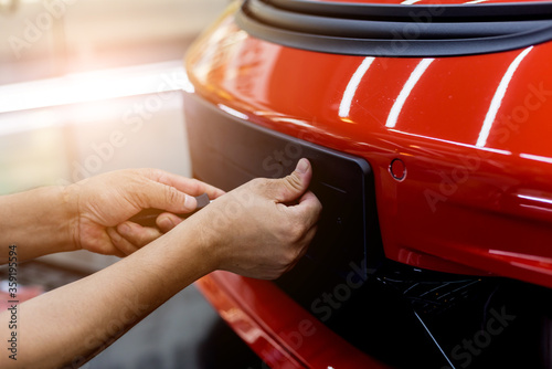 Technician changing car plate number in service center.