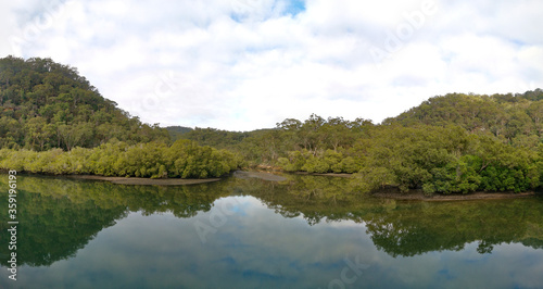 Beautiful morning panoramic view of Cockle creek with reflections of foggy sky  mountains and trees  Bobbin Head  Ku-ring-gai Chase National Park  New South Wales  Australia