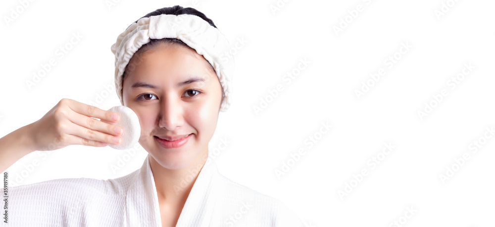Young woman cleaning beauty face by wiping, using cotton pads cleansing lotion facial toner. Attractive beautiful young girl has beautiful facial skin with smile face, happy. Facial skin care concept Young woman cleaning beauty face by wiping, using cotton pads cleansing lotion facial toner. Attractive beautiful young girl has beautiful facial skin with smile face, happy. Facial skin care concept