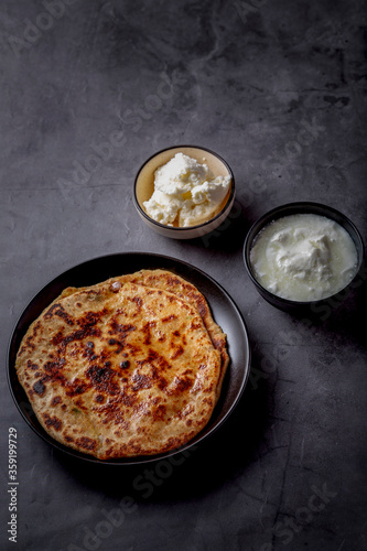 Aaloo parantha or stuffed potato flatbread with curd and white butter