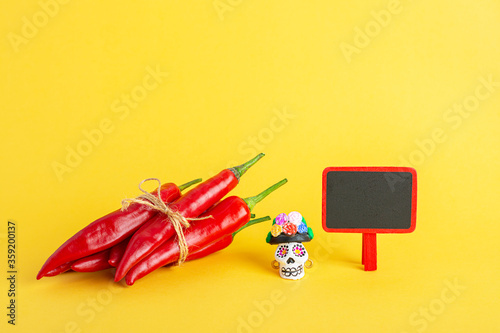 Red hot chili pepper and Catrina La Calavera Garbancera , Dapper Skeleton, Elegant Skull and small blackboard photo