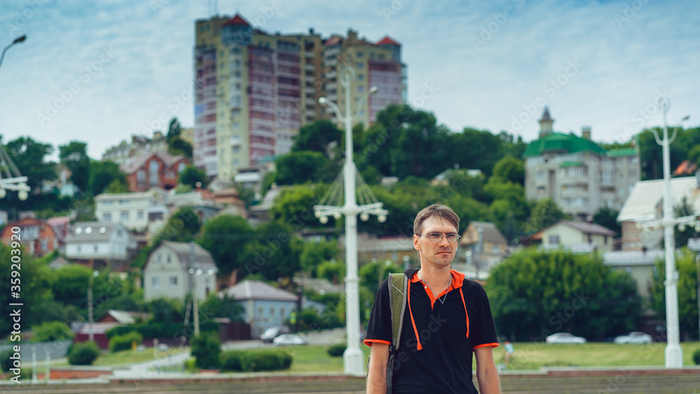 Man standing in yard of city. Portrait of young man in casual clothes standing. Man standing in yard of city. Portrait of young man in casual clothes standing.