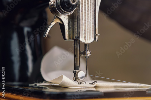 presser foot and needle with thread of vintage sewing machine in light room