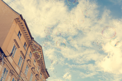 Many bubbles floating in the city sky.