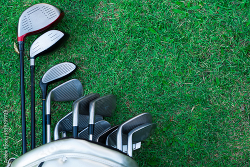 Closeup old golf bags on green. Set of golf clubs over green field background