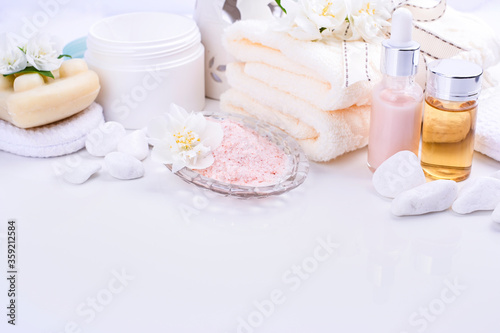 Various spa and beauty threatment products isolated on white background. Skin cream, tonicum bottle, dry flowers, leaves, rose and Himalayan salt. Organic cosmetics, spa concept. Empty. Copy space photo