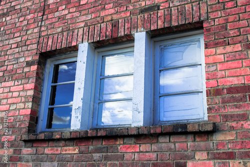 Old brick house with vintage blue and white windows photo