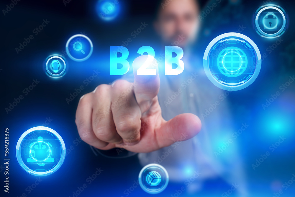 Business, Technology, Internet and network concept. Young businessman working on a virtual screen of the future and sees the inscription: B2B Business, Technology, Internet and network concept. Young businessman working on a virtual screen of the future and sees the inscription: B2B