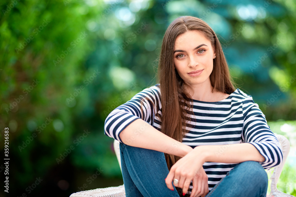 Attractive relaxed woman sitting in the garden at home Attractive relaxed woman sitting in the garden at home