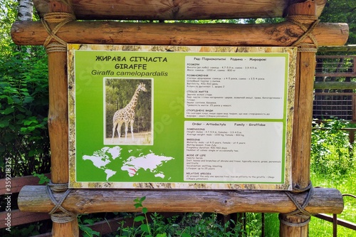 Information of giraffe on info board in city zoo photo