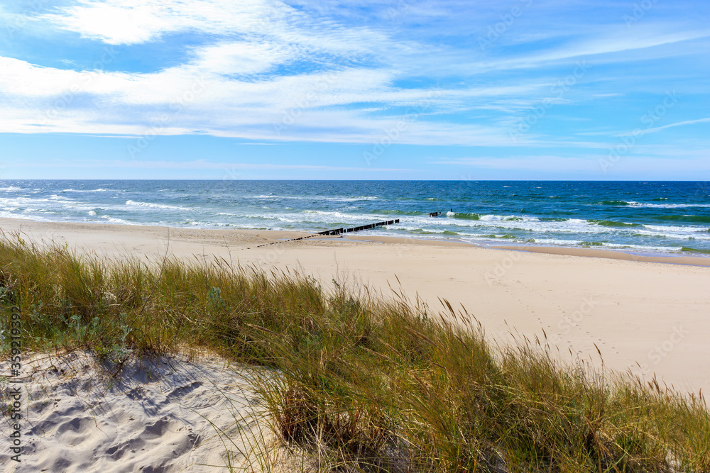 Grass sand dunes and beautiful white sand beach with blue sea near Kolobrzeg, Baltic Sea coast, Poland Grass sand dunes and beautiful white sand beach with blue sea near Kolobrzeg, Baltic Sea coast, Poland