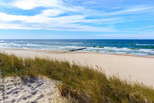 Grass sand dunes and beautiful white sand beach with blue sea near Kolobrzeg, Baltic Sea coast, Poland