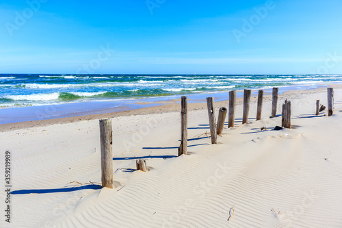 Wooden breakwaters on beautiful white sand beach with blue sea near Kolobrzeg  Baltic Sea coast  Poland