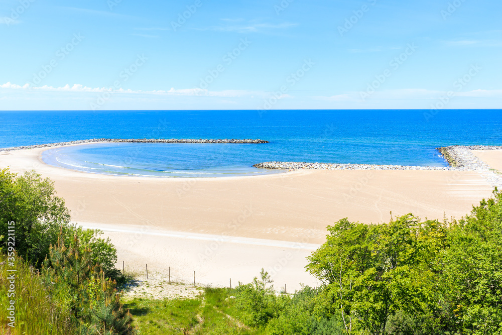 View of beautiful white sand beach with blue sea in Jaroslawiec village, Baltic Sea coast, Poland