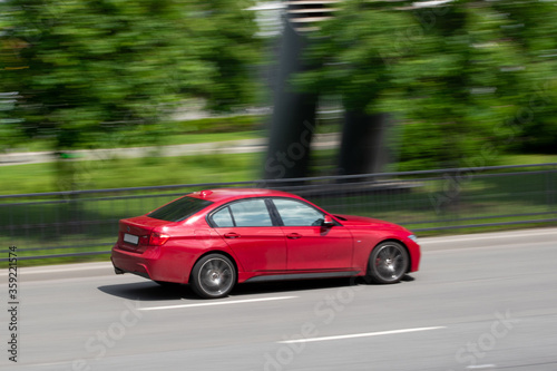 Red car rides on the road. Motion blur photo