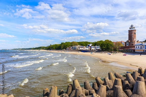 Lighthouse and beautiful white sand beach and blue sea in Kolobrzeg, Baltic Sea coast, Poland