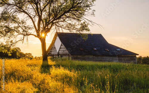 An old abandoned barn under sunset with sunburst, sunstars photo