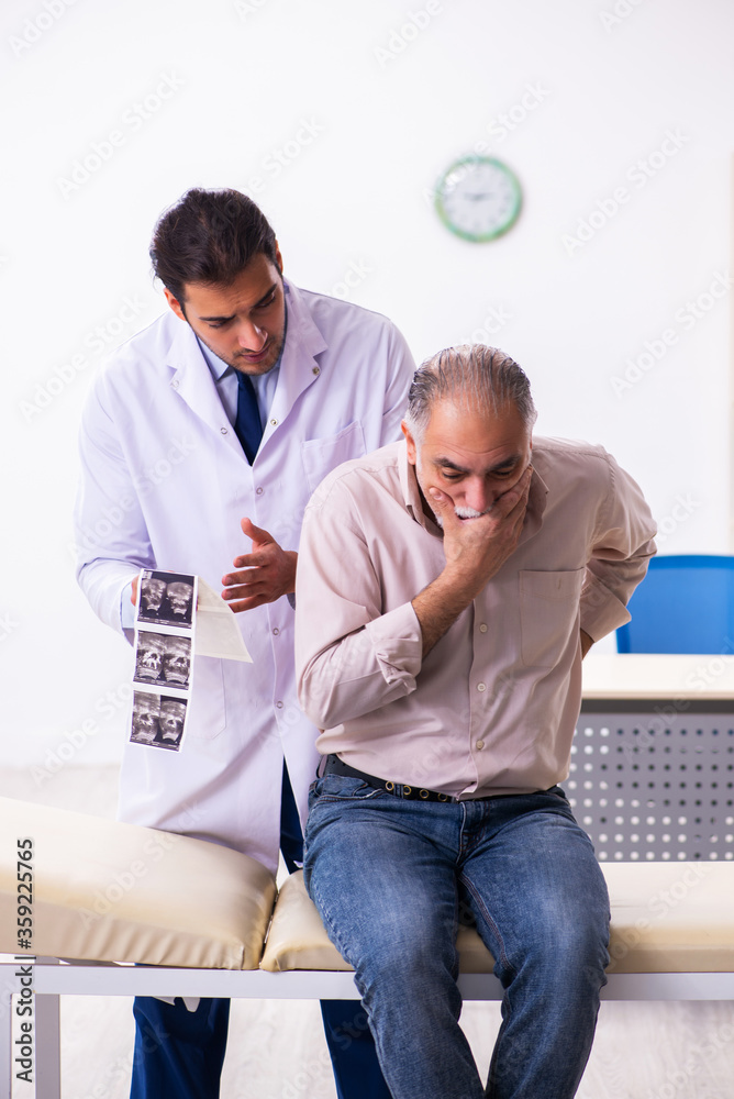 Old patient visiting young male doctor Old patient visiting young male doctor