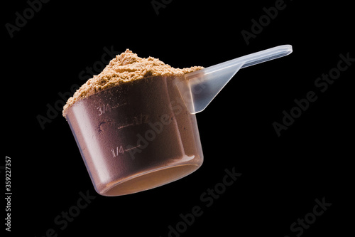 Tableau sur toile A scoop of chocolate protein powder drink isolated on black background